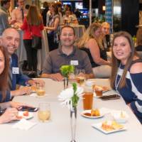 5 attendees pose for a picture at a table